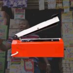 Orange 8 inch hand impulse sealing machine with arm raised