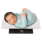 A baby sleeping on a weighing machine