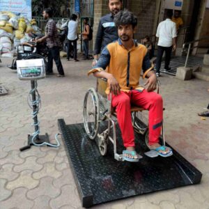Patient seated in a wheelchair on the HSCo wheelchair scale