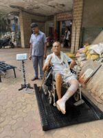 Elderly patient in a wheelchair being weighed on the ramp platform